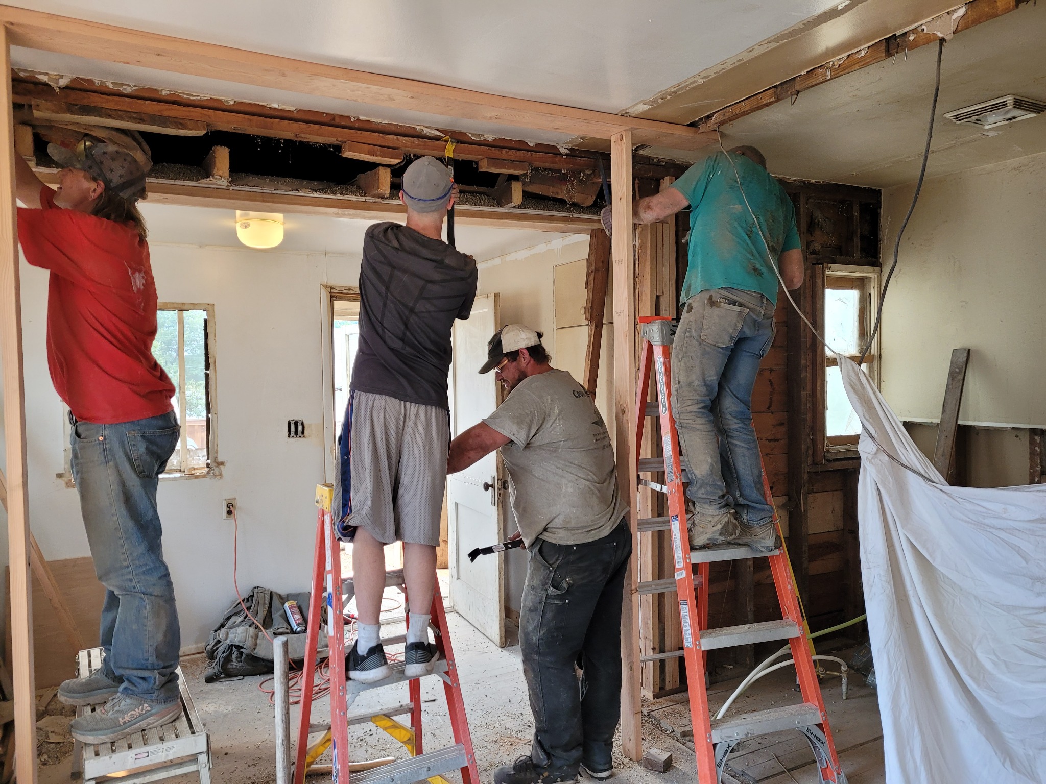 Employees working together on the beam between the kitchen and living area